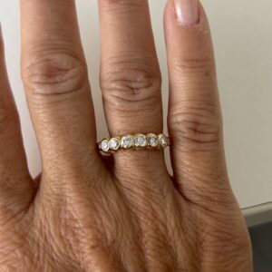 Foto gioiello indossata: anello oro giallo con diamanti riviere