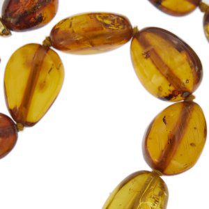 zoom dettaglio particolare pietra preziosa ambra su collana in oro