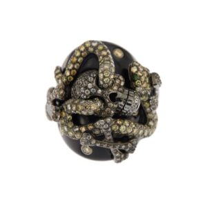 Anello in oro bianco 18 kt brunito ricoperto di onice nero su cui è presente un teschio, un serpente e tre paia di ossa incrociate. Il tutto impreziosito da 350 diamanti naturali, taglio brillante: 7 diamanti da 0.05 ct cad., 111 diamanti da 0.01 ct cad. (ossa), 145 diamanti da 0.03 ct cad. (serpente) e 87 diamanti da 0.02 ct cad. (teschio), totale di circa 7,55 ct - colore trasparenti e fancy (yellow, champagne e brown) e purezza VS. Gli occhi del serpente sono 2 piccoli smeraldi da 0.02 ct cad.