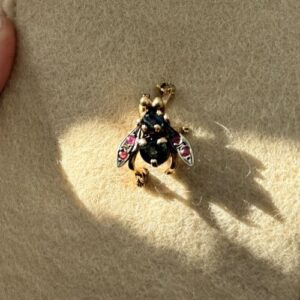 Foto gioiello indossata: spilla a forma di mosca in oro rosa con rubini e zaffiri