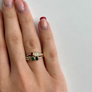Foto gioiello indossata: anello in oro giallo con diamanti e zaffiro, rubino e smeraldo
